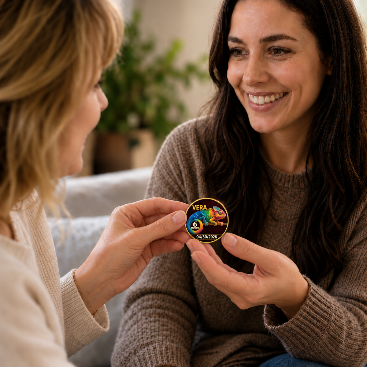Personalized gold recovery coin with colorful chameleon design, held between two people