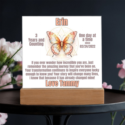 Butterfly LED sobriety plaque with wood base on dark table, name Erin