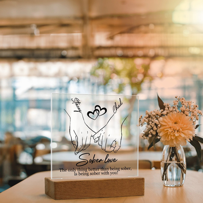 Sober love LED plaque with clear panel, hands-and-heart line art, wood base on table