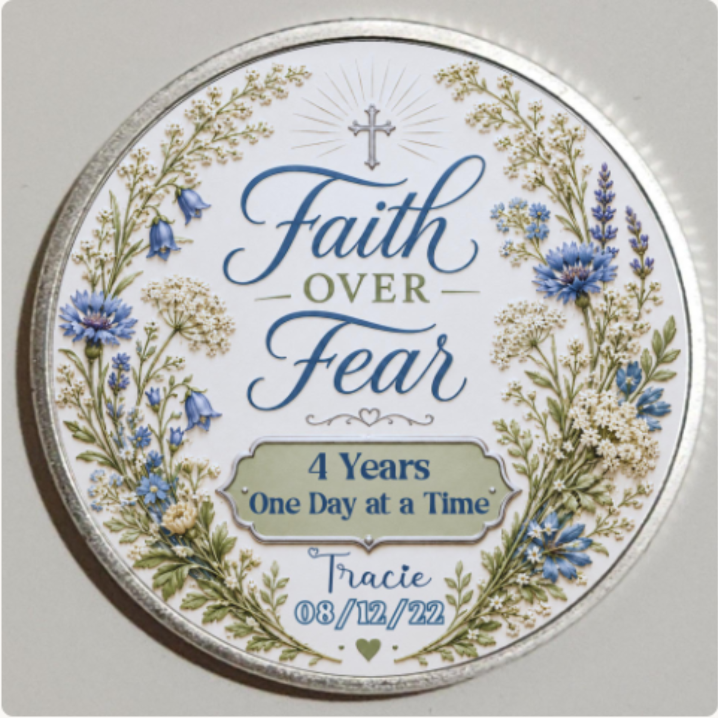 Close-up silver round recovery coin reading “Faith Over Fear” and “4 Years One Day at a Time”