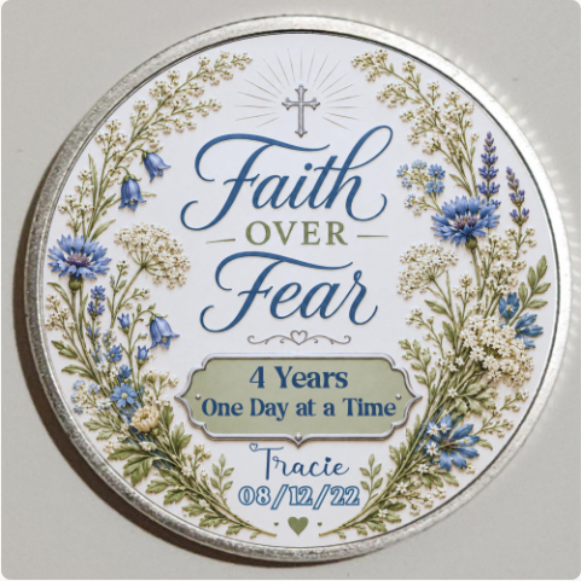 Close-up silver round recovery coin reading “Faith Over Fear” and “4 Years One Day at a Time”