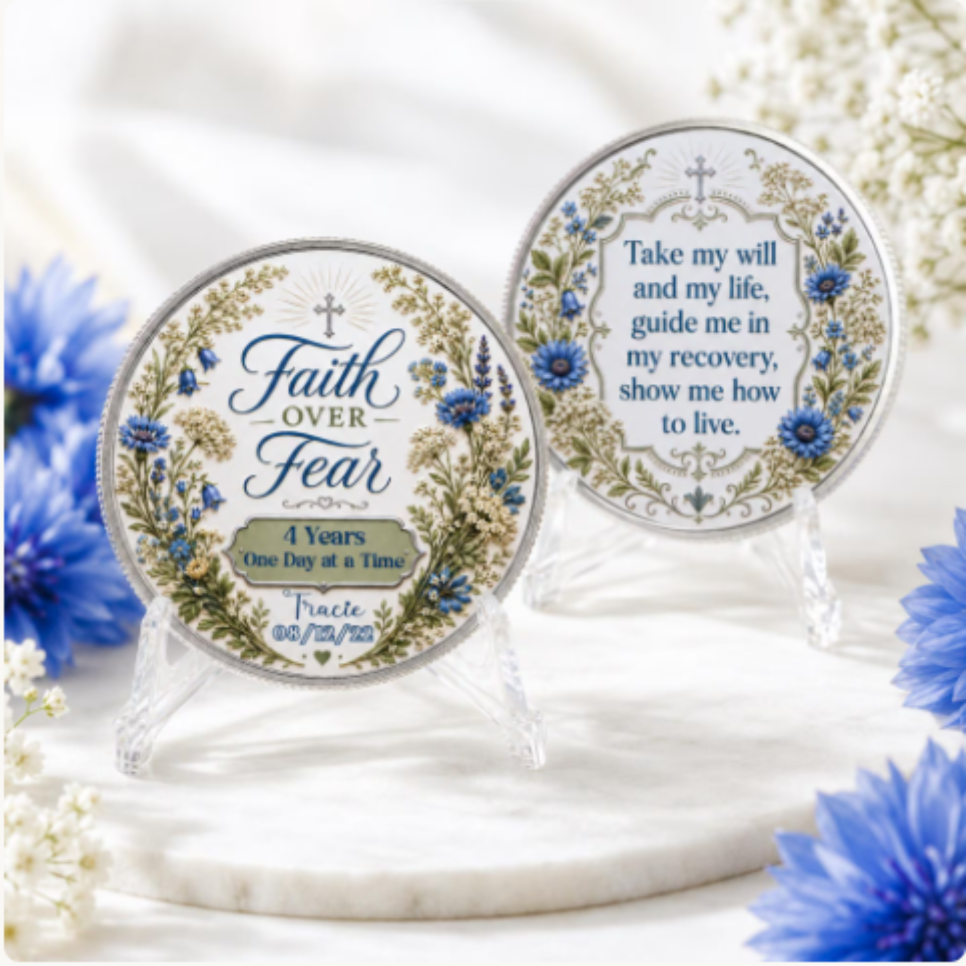 Two round “Faith Over Fear” recovery coins on clear stands