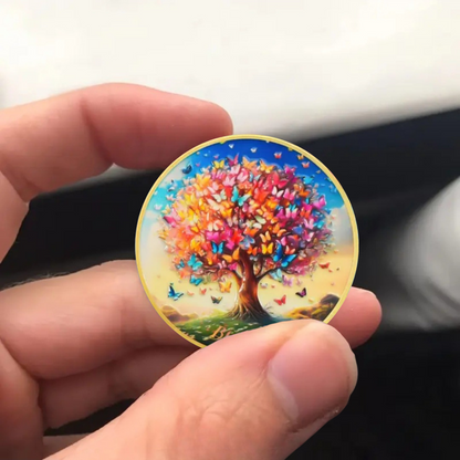 Sobriety coin in hand featuring butterfly tree artwork with gold rim and gold lettering