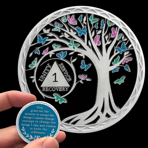 Silver-toned coin with black center, tree of life and colorful butterflies, in capsule