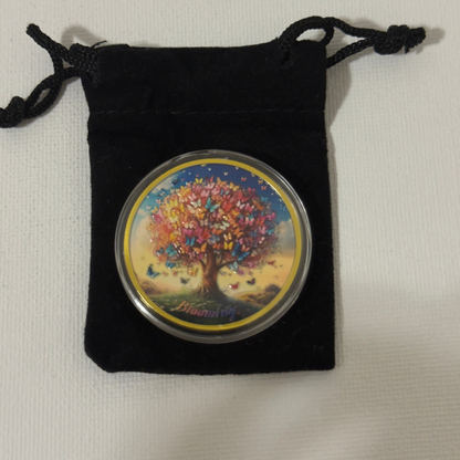 Sobriety coin in black velvet drawstring pouch, butterfly tree side visible with gold rim