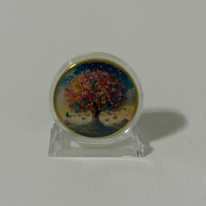 Sobriety coin on clear plastic stand, butterfly tree artwork side visible with gold rim