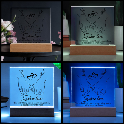 Sober love LED plaque with hands-and-heart design, wood base, shown with blue glow