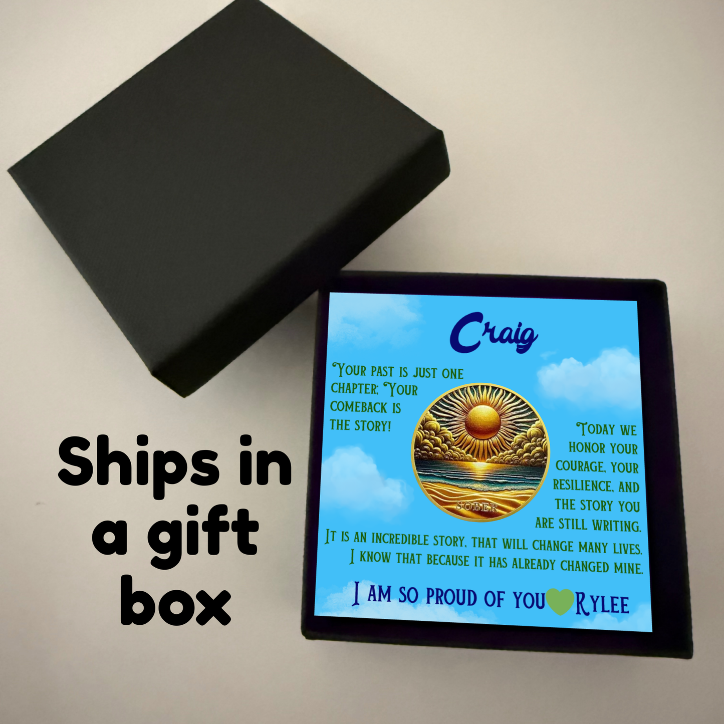 Black gift box with greeting card featuring Craig name and gold sun-over-ocean coin
