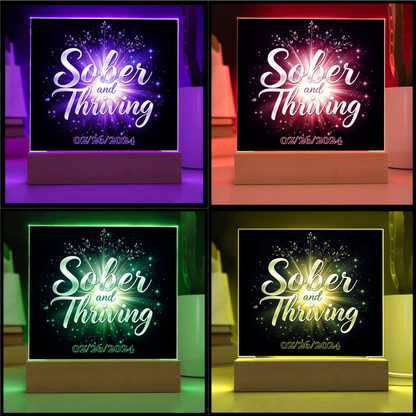 LED acrylic plaque with 'Sober and Thriving' and date on wood base, vibrant border colors