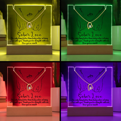 LED base with illuminated hands and heart pendant artwork in yellow, green, red, and purple
