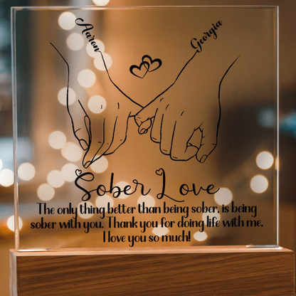 LED sobriety plaque with hands-heart design and message, warm amber glowing frame, wood base