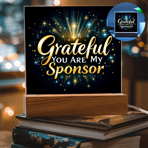 Grateful sponsor LED plaque with golden glowing rays on black sign and wood base
