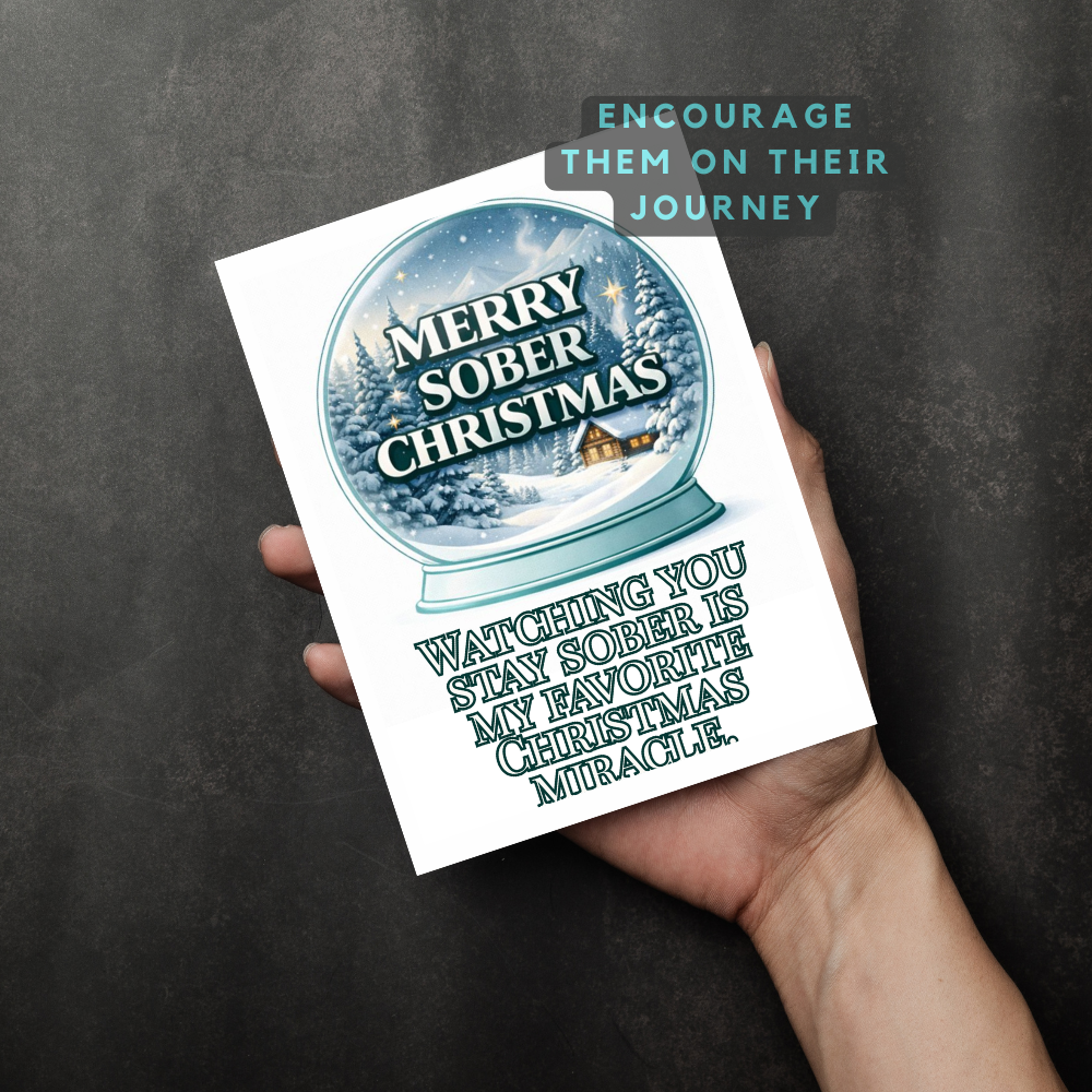 Christmas printable card held in hand with snow globe design and Merry Sober Christmas text
