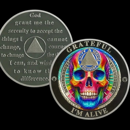 Two round sobriety coins showing rainbow skull center and Serenity prayer text