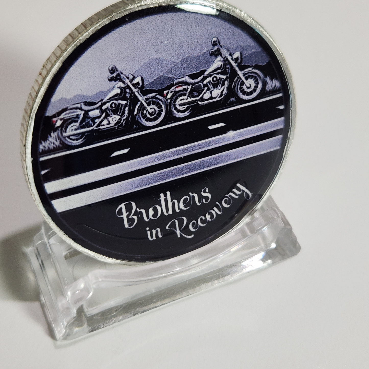 Sobriety coin with motorcycle graphic and 'Brothers in Recovery' text, clear stand