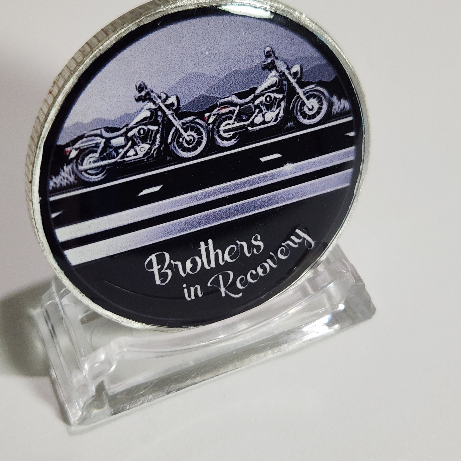 Sobriety coin with motorcycle graphic and 'Brothers in Recovery' text, clear stand