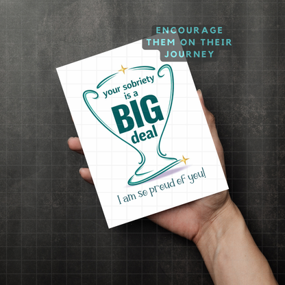 Sobriety encouragement card held by hand with teal 'Big deal' heart.