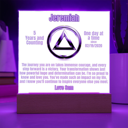 Personalized LED plaque with circular emblem and wooden base, purple-lit glowing panel