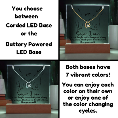 LED light base with glowing hands and heart pendant design on a wooden stand
