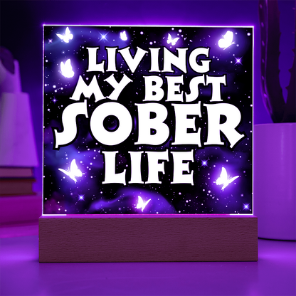 Square LED acrylic plaque on wood base, purple glow with "Living My Best Sober Life".