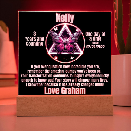 Personalized LED milestone plaque with red glowing butterfly emblem on wooden base