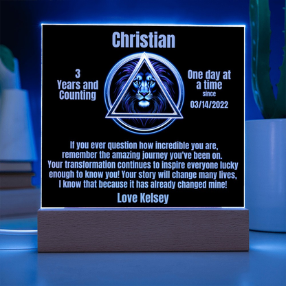 Square LED plaque on wood base glowing with Christian triangle lion design and date