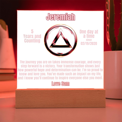 Personalized LED plaque with circular emblem and wooden base, red-lit glowing panel