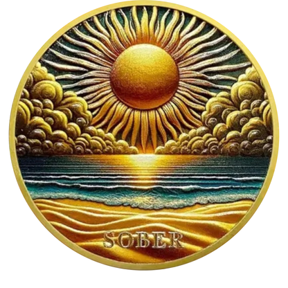 Round gold sobriety coin with sunrise over ocean and clouds, text SOBER