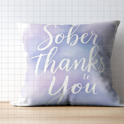 Blue and white decorative throw pillow with script text "Sober Thanks to You"