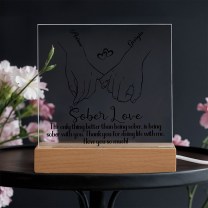 LED sobriety plaque with hands-heart design and message on wood base, cord visible