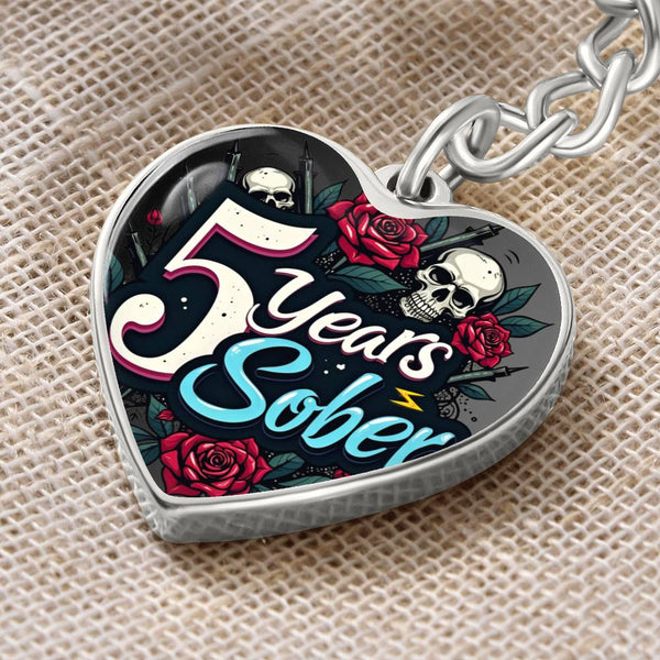 Silver heart keychain with '5 Years Sober' lettering, roses, and skull graphic