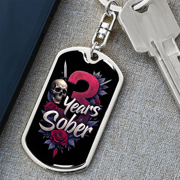 Silver dog tag keychain with black enamel art: pink '3' and 'Years Sober' with skull and roses