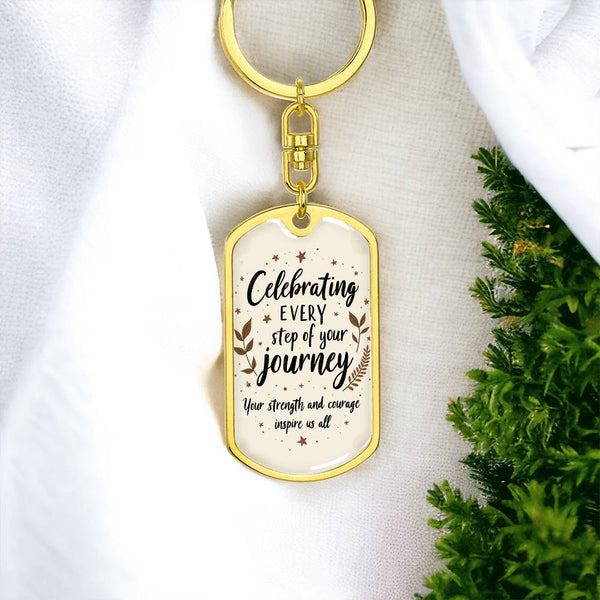 Gold dog tag swivel keychain with “Celebrating every step of your journey” message.
