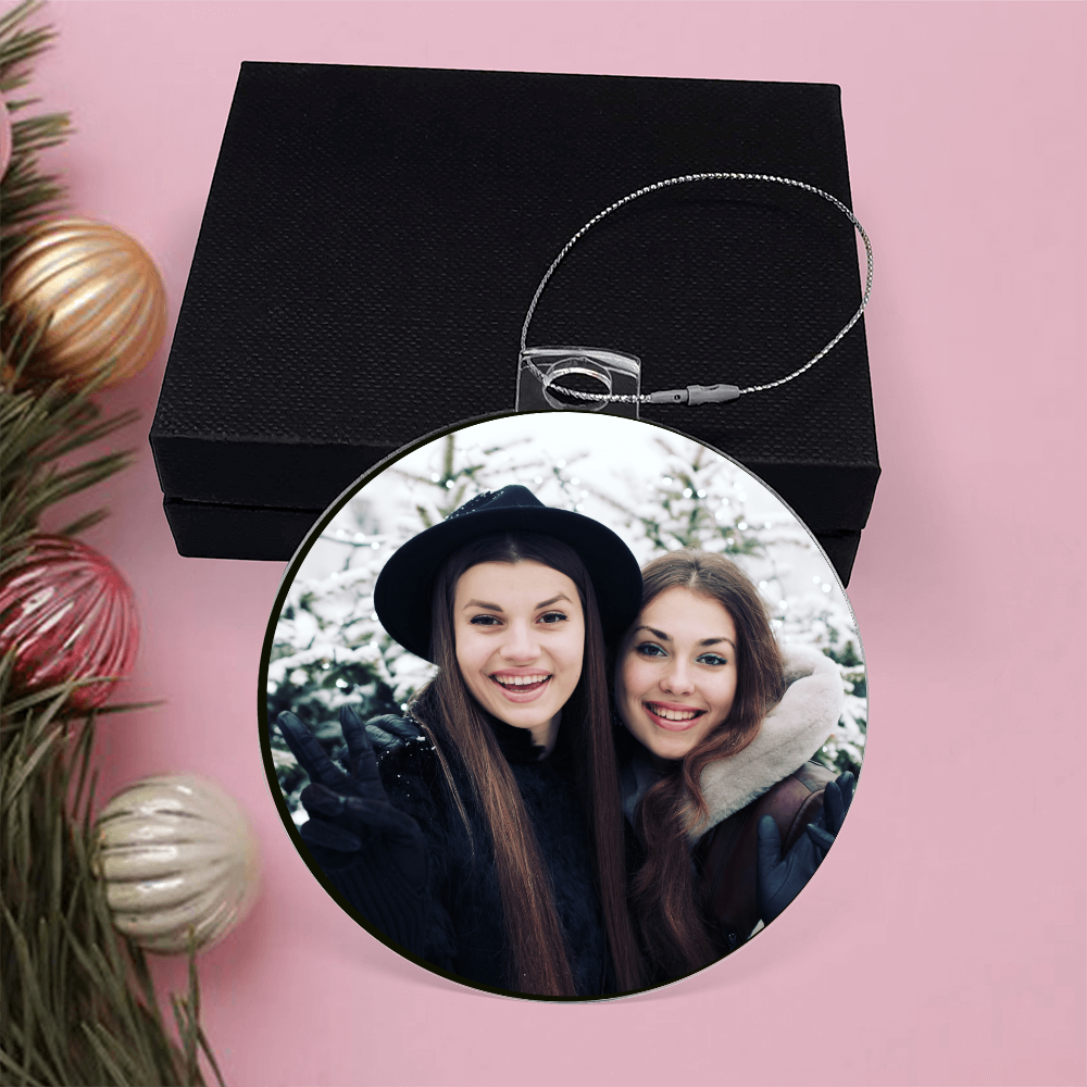Round acrylic photo ornament with two-women portrait, on black gift box