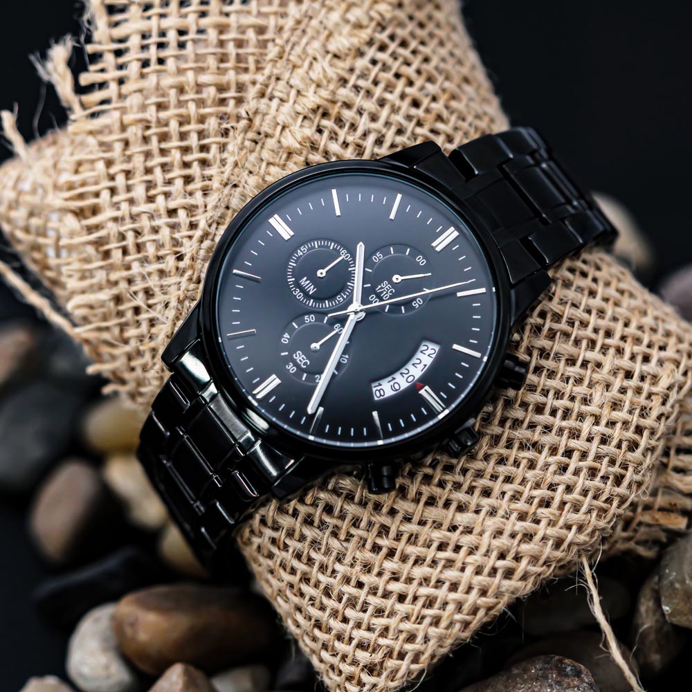 Black chronograph watch on dark metal bracelet with dial and subdials