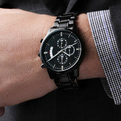 Black chronograph watch worn on wrist with metal bracelet