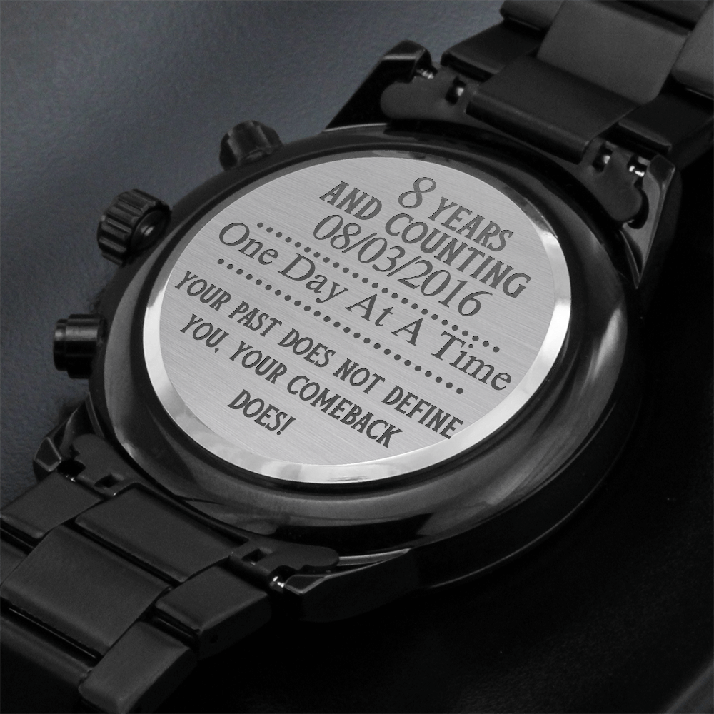 Black men’s chronograph wristwatch with engraved case back cover text