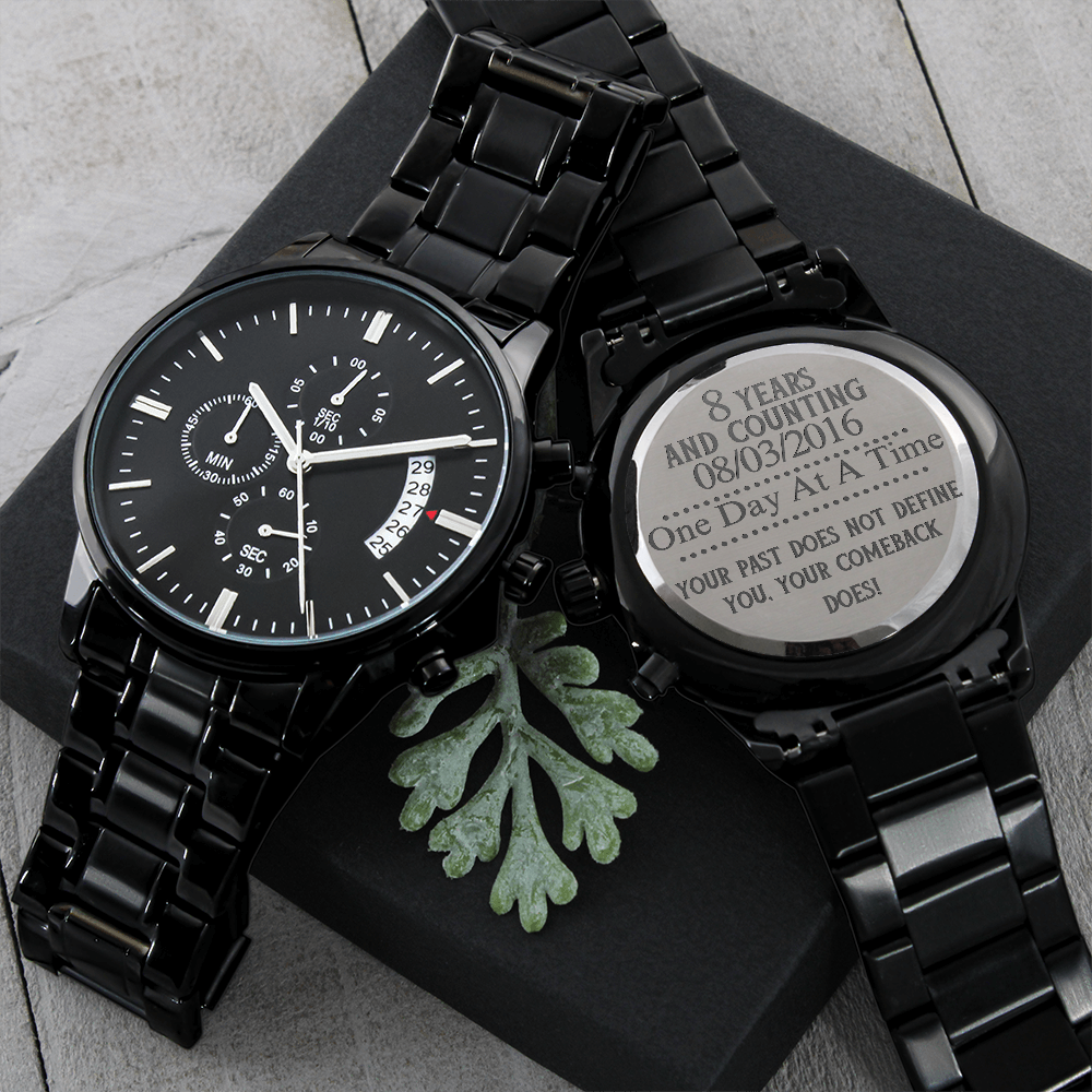 Black men’s chronograph wristwatch with engraved back disc on dark box