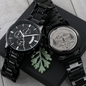 Black chronograph watch with engraved case-back disc and metal link bracelet