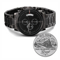 Black chronograph wristwatch with metal link bracelet, engraved gift coin included