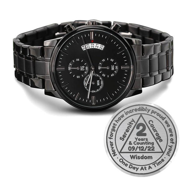 Black metal wristwatch with multi-dial face and circular badge marked 2 Years & Counting