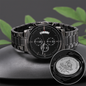 Black stainless steel chronograph watch with engraved back medallion on dark surface