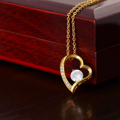 Gold heart pendant necklace with round center stone and crystal details, on chain