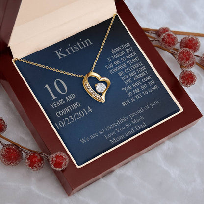 Heart pendant necklace with gold-tone chain on blue gift card in maroon box
