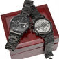 Black chronograph wristwatch pair: front dial and engraved case-back coin on box