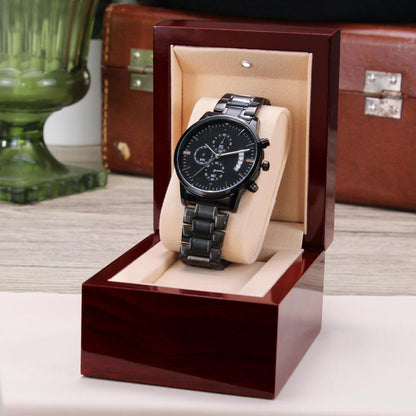 Black chronograph watch on cushion inside a red gift box
