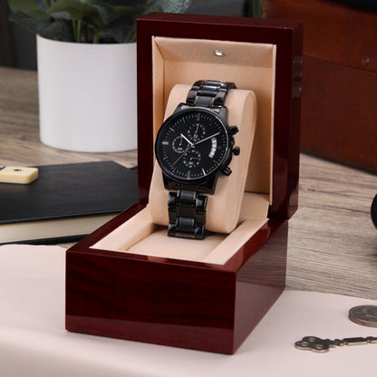 Black men’s chronograph wristwatch in open wooden-style box with beige cushion