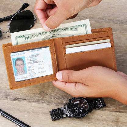 Open tan leather wallet with printed front, holding cards with a hand