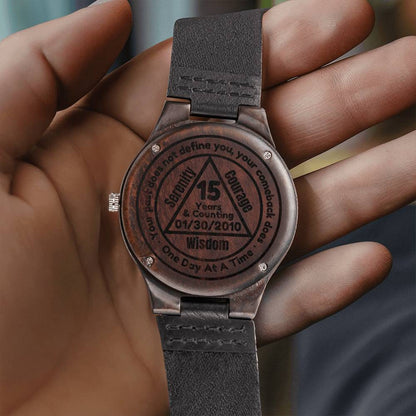 Engraved wood watch with black leather strap, round face and etched 15-year text