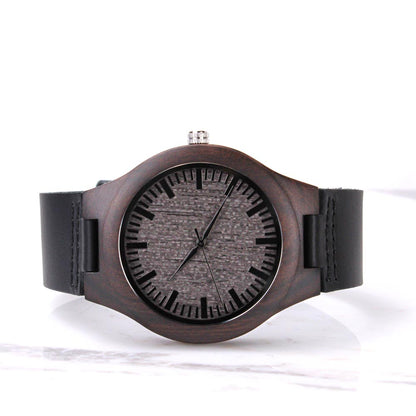 Wood watch with black leather strap, round dark dial with three metal hands